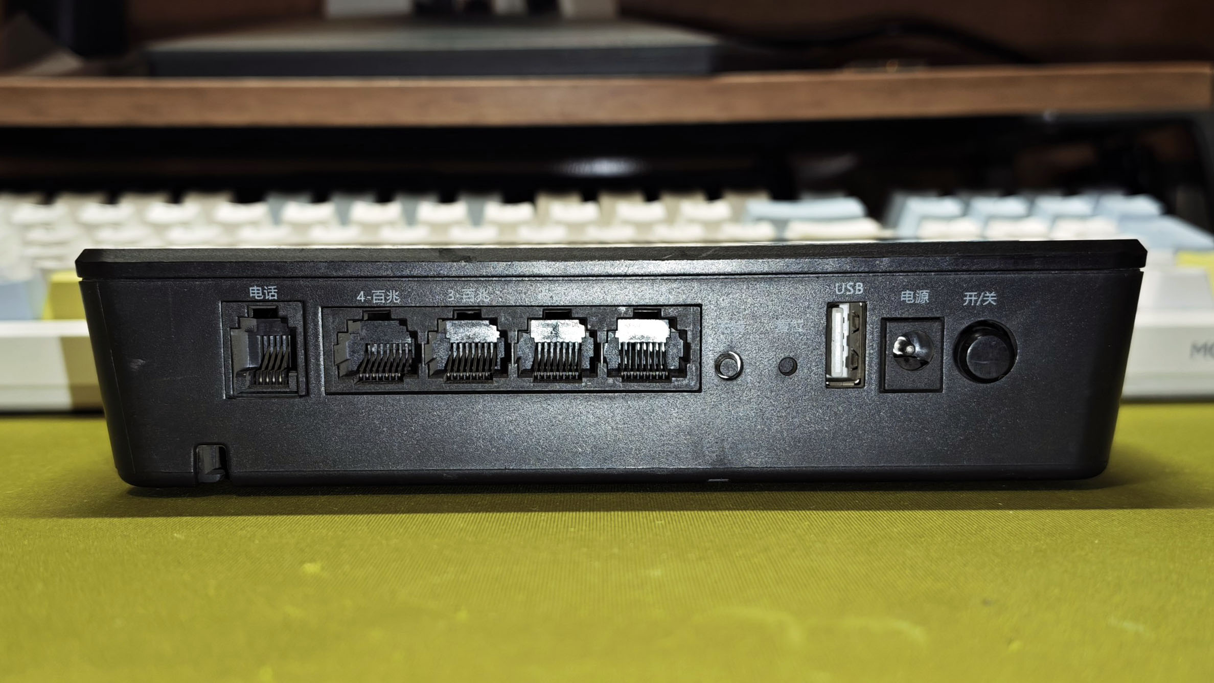 KD-YUN-811G 接口面：电话口、4 个百兆网口（丝印 4-百兆、3-百兆）、复位孔、USB-A、12V 电源插座与电源开关