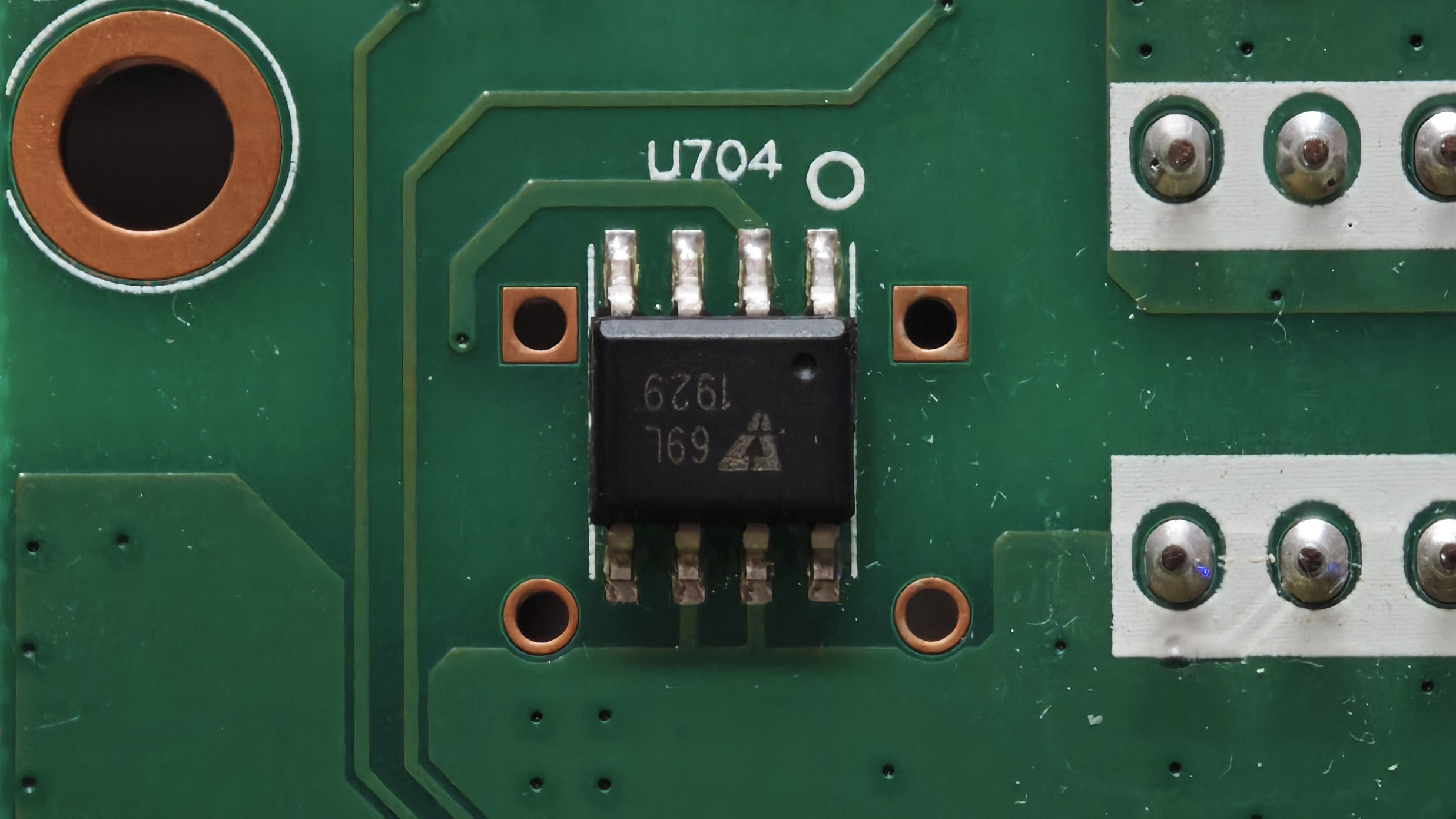 位号 U704 的 8 脚芯片特写：丝印 1529 与 169 加一个三角形厂标，型号未能识别