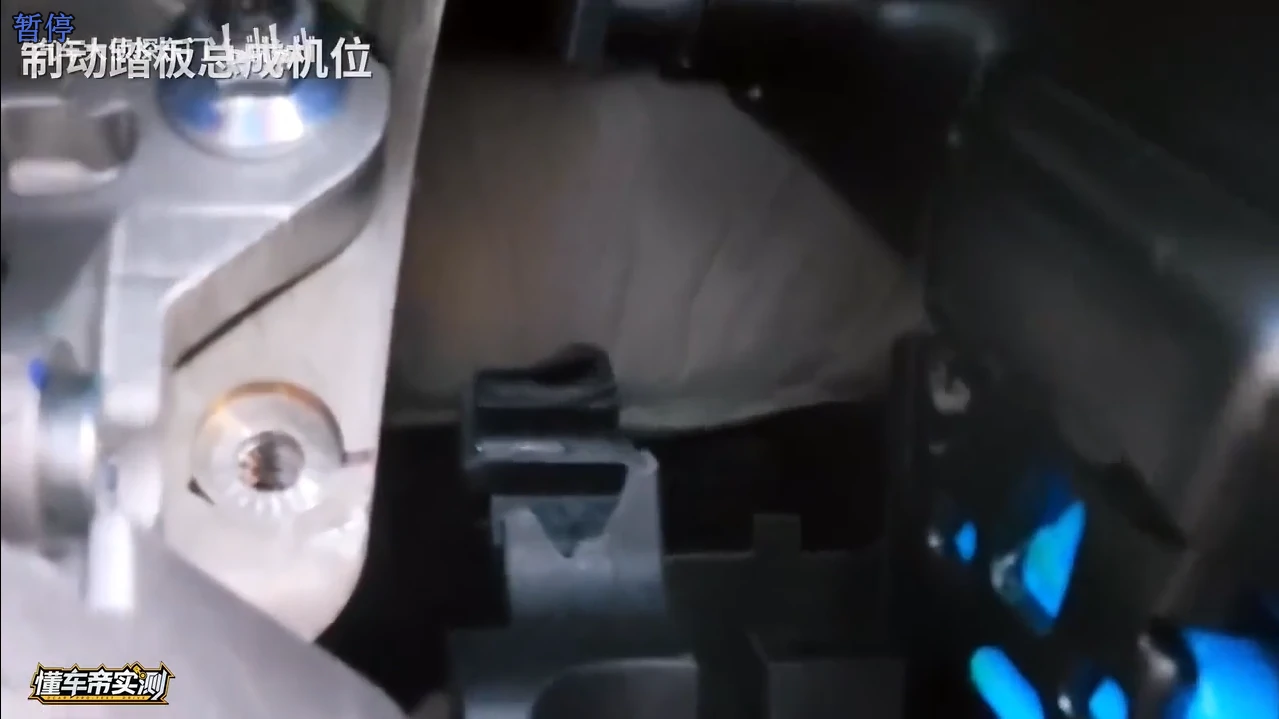 视频暂停帧:制动踏板总成安装机位特写,可见踏板臂、支架与固定螺栓的相对位置
